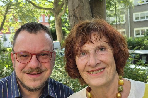 Erfolgsgeschichte FAS Tim Puffler und sein Mutter Monika Reidegeld nebeneinander draußen, sie lächeln in die Kamera.